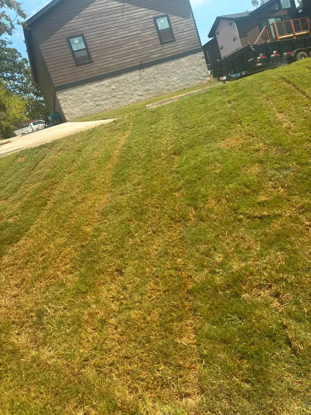 Fresh sod rows beside a brick home
