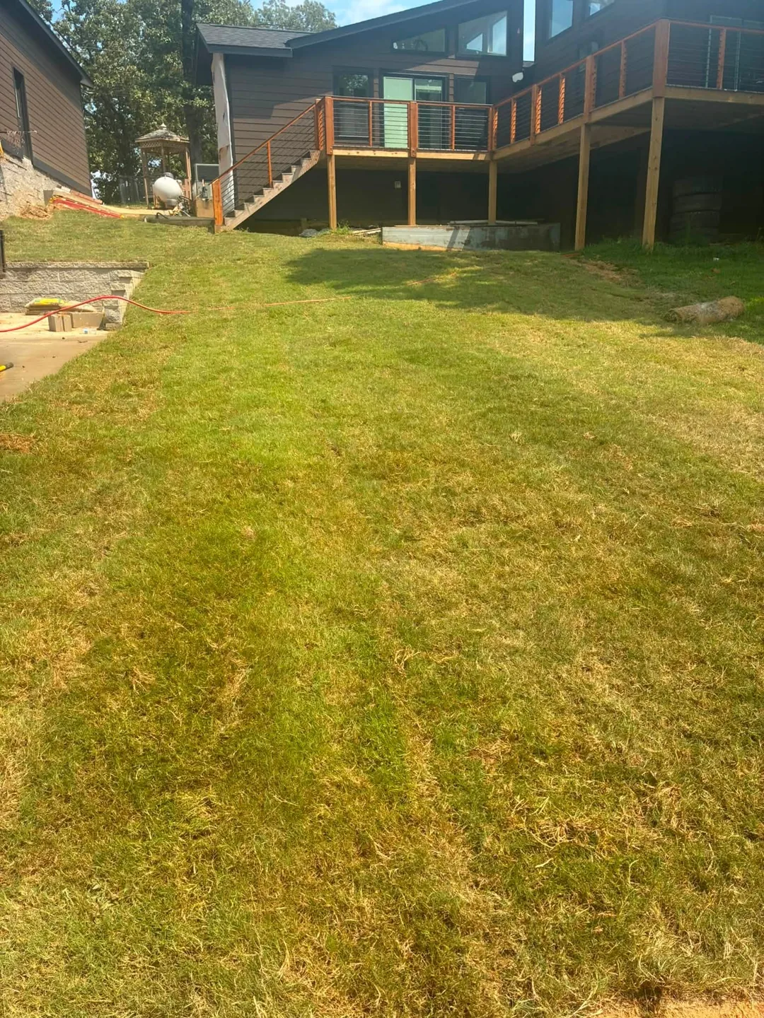 New lawn extending from a house and elevated wooden deck