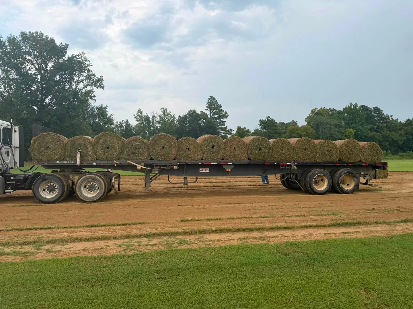 Flatbed trailer loaded with large rolls of harvested sod